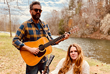 Musicians Jo & Ray holding their guitars